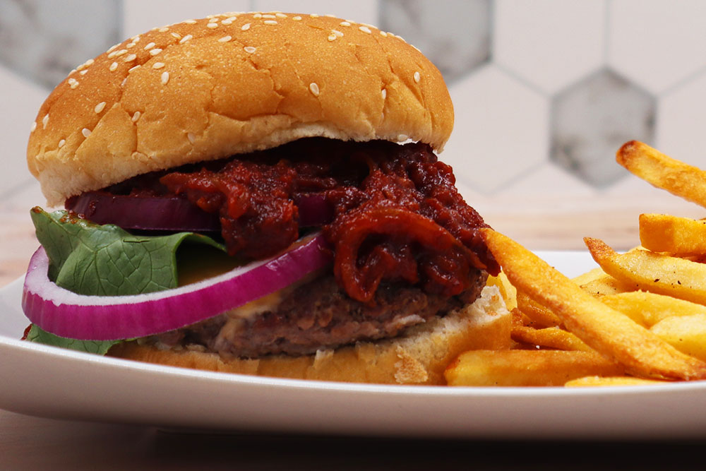 Image of our Easy Tomato Bacon Jam Recipe on a burger